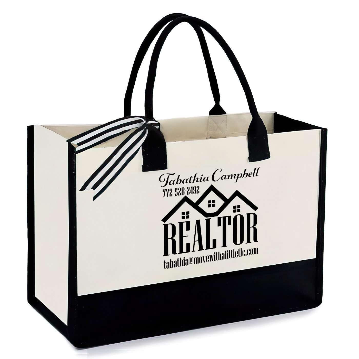 White and black realtor tote bag with black handles and a ribbon